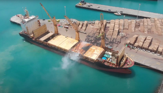 An aerial photo of Kota Bahagia shows smoke from the cargo hold fire in the New Zealand port of Napier in December 2020. Image: James Hooker/TAIC Image:An aerial photo of Kota Bahagia shows smoke from the cargo hold fire in the New Zealand port of Napier in December 2020. Image: James Hooker/TAIC