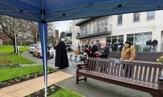 Image:A service attended by residents and staff outside the Trinity House Hub at Nautilus Mariners' Park presided  over by Reverend Alan Leach. 